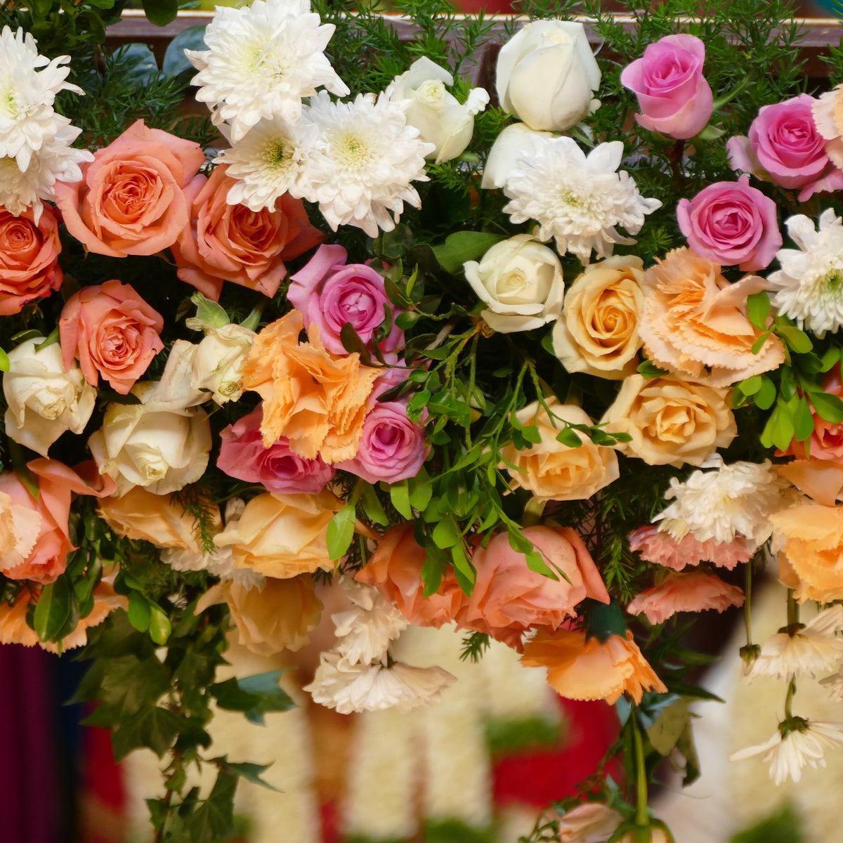 A fresh-flower wedding backdrop of roses, carnations and white chrysanthemums with greenery