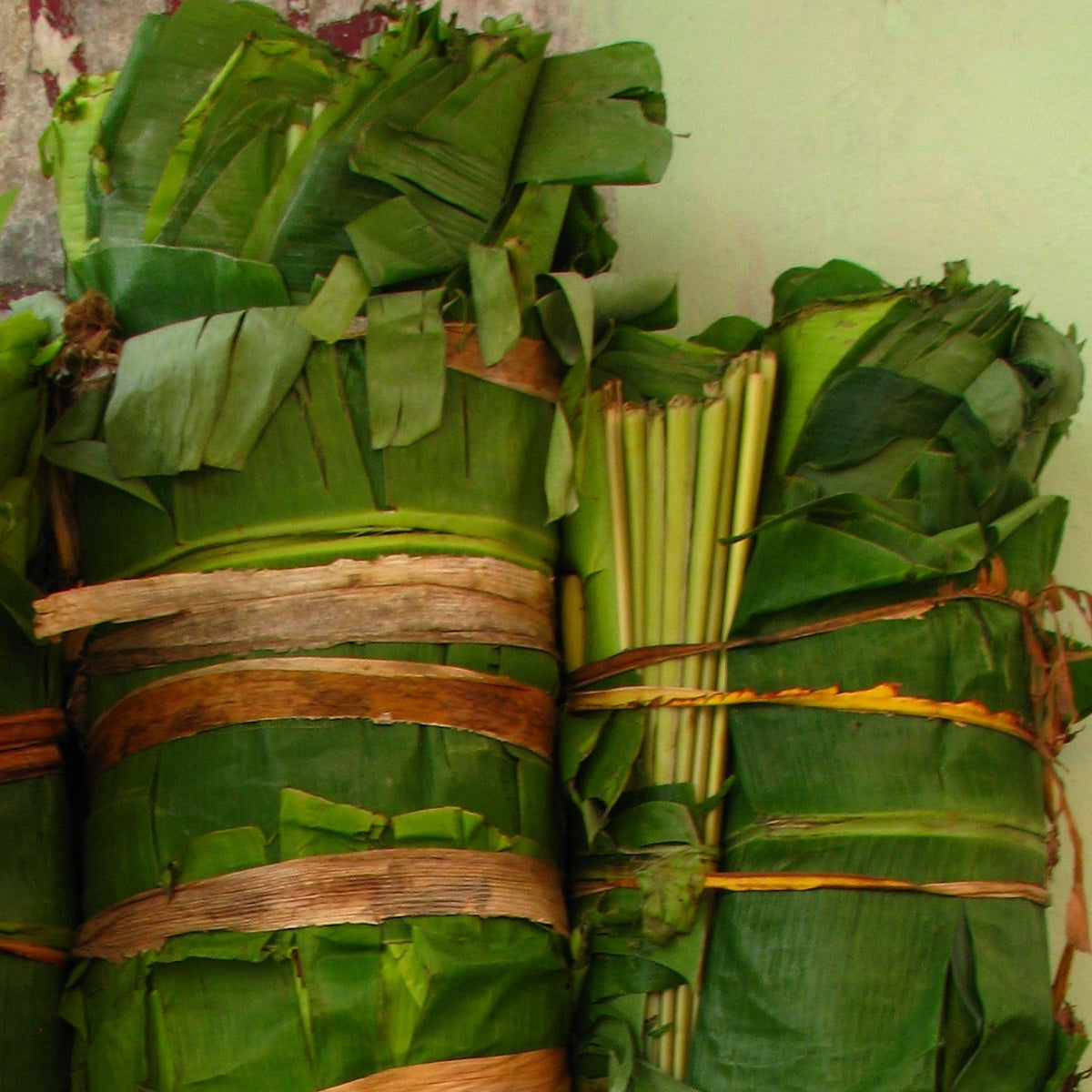 Large tied bundles of banana leaves at a market