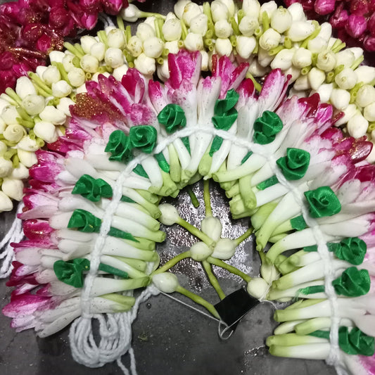 A bridal flower jada of white buds and magenta-tipped tuberose, laid out flat
