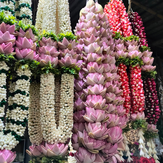 Hanging garlands of folded pink lotus petals, jasmine buds and rose buds with tuberose tassels