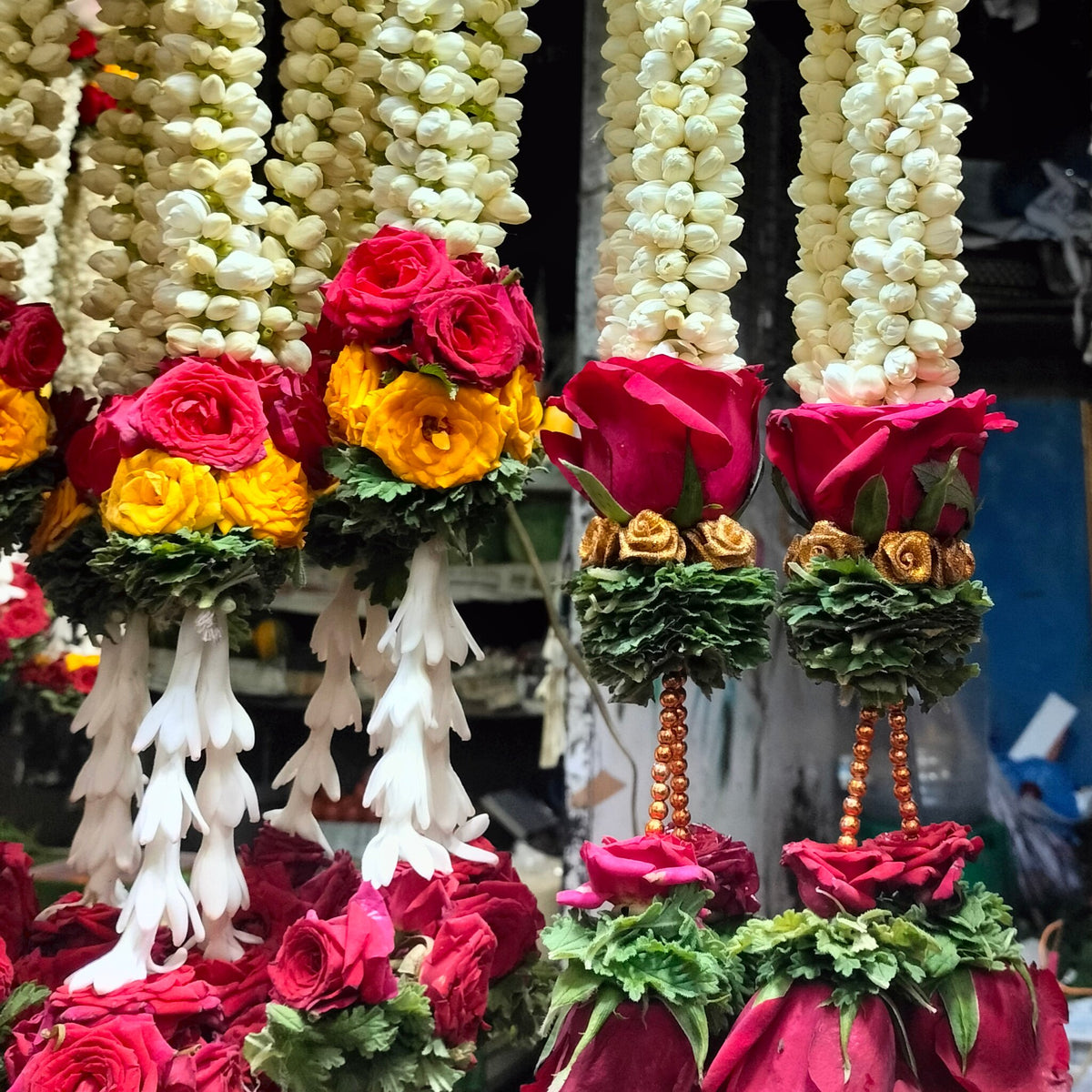Thin hanging garlands of jasmine buds ending in rose clusters and tuberose tassels